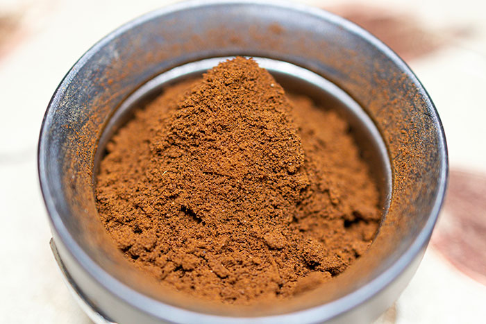 Close-up of finely ground spice in a metal container, illustrating an unusual texture related to kids in school weirdo stories.