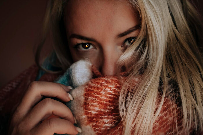 Close-up of a woman partly hiding her face with a colorful scarf, conveying emotions tied to infidelity getting exposed stories.