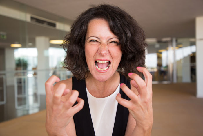 A woman with dark hair screaming in anger, hands clenched, symbolizing a mom's reaction, leaving people speechless.
