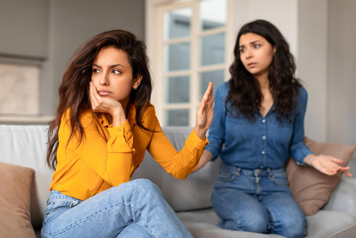 Two women having a tense conversation on a couch, depicting a family conflict involving a sister and her boyfriend.