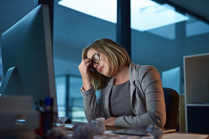 Woman stressed at her office desk, struggling with the commute after work from home was canceled. Woman stressed at her office desk, struggling with the commute after work from home was canceled.