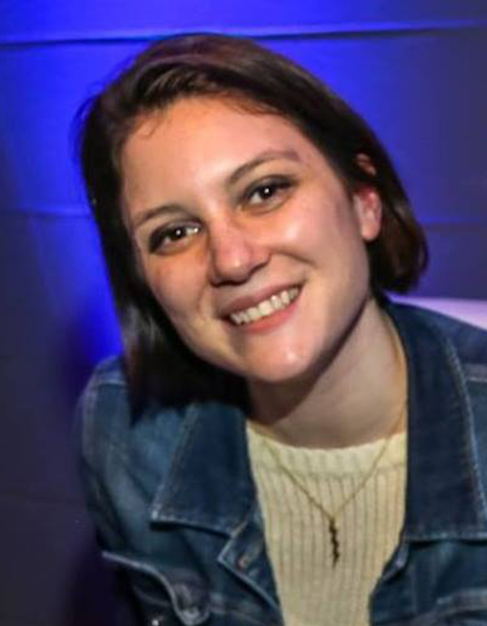 Young woman smiling in casual clothes, related to the string of missing or deceased scientists raising alarm.