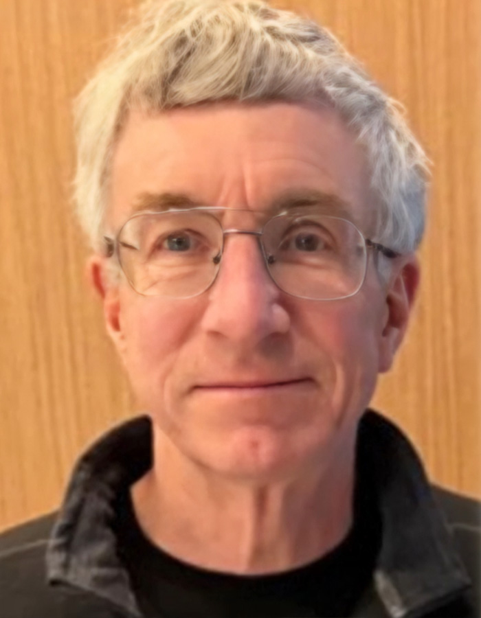 Older man wearing glasses and a black jacket, representing concerns over missing or deceased scientists cases.