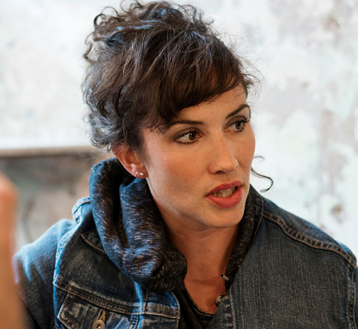 Woman in a denim jacket engaged in a thoughtful conversation showing subtle and interesting displays of intelligence