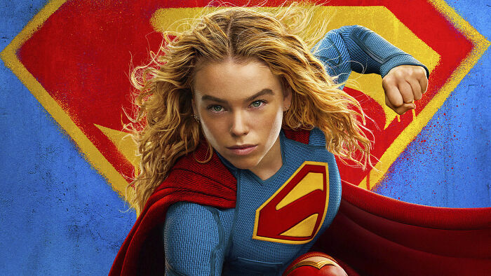 Supergirl star Milly Alcock in costume with cape flying, preparing for challenges and backlash in her role.