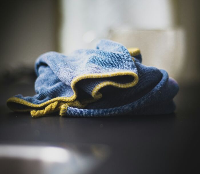 Folded blue cloth with yellow edges resting on a dark surface, evoking moments gynecologists reflect on challenging appointments.