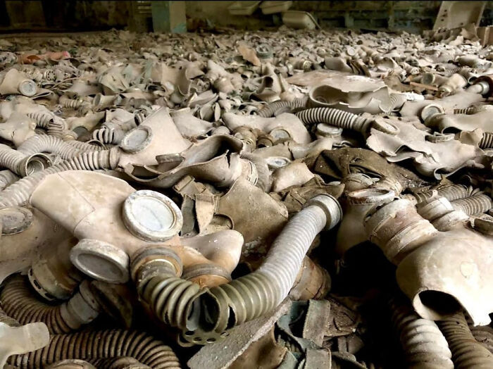 Pile of old, dusty gas masks with hoses scattered on the floor, representing events from 1960 to 2010.