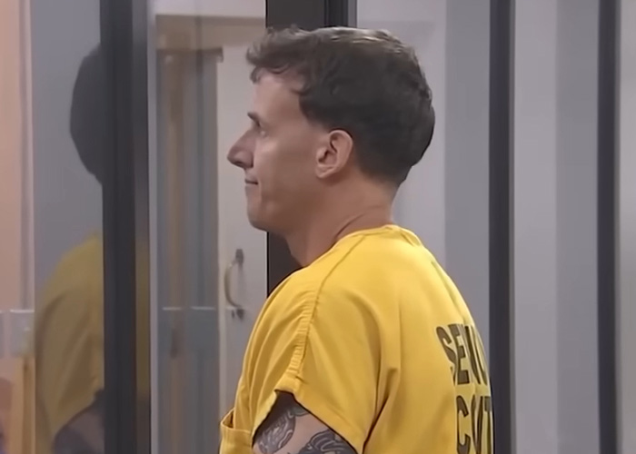 Homem em uniforme de prisão amarelo com tatuagem no braço, em uma cela, parente de professora que supostamente está construindo relacionamento com a mãe