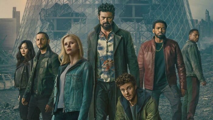 The Boys Season 5 cast standing in a post-apocalyptic urban setting wearing dark and casual outfits. The Boys Season 5 cast standing in a post-apocalyptic urban setting wearing dark and casual outfits.