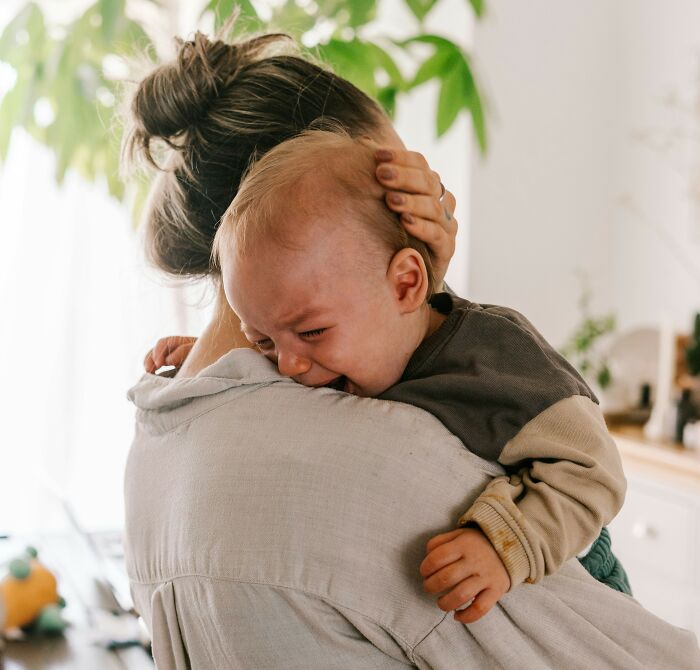 A baby cries on a person's shoulder, demonstrating disturbing sounds.