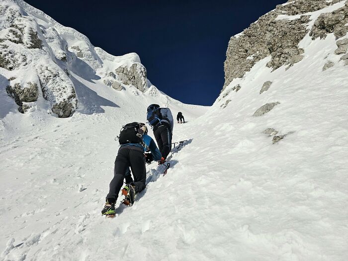 Climbers ascending a steep snowy mountain slope, highlighting moments when being late took the darkest turn.
