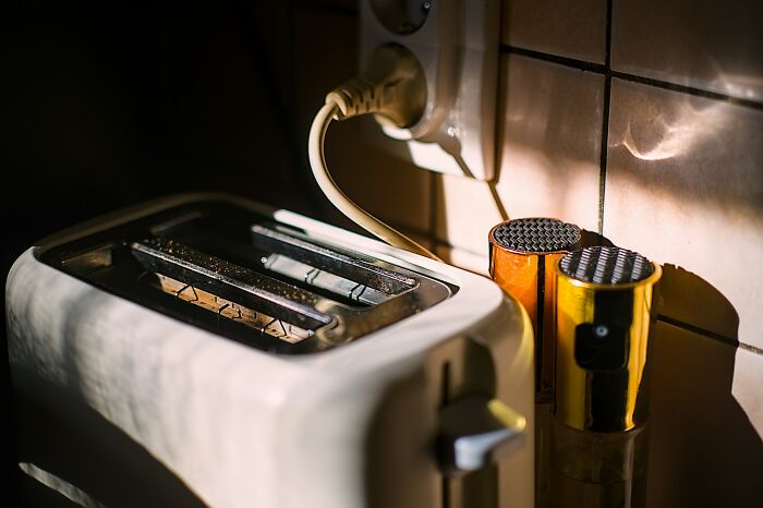 Toaster plugged into a wall outlet next to kitchen containers, illustrating childhood dumbest survival instincts concept.