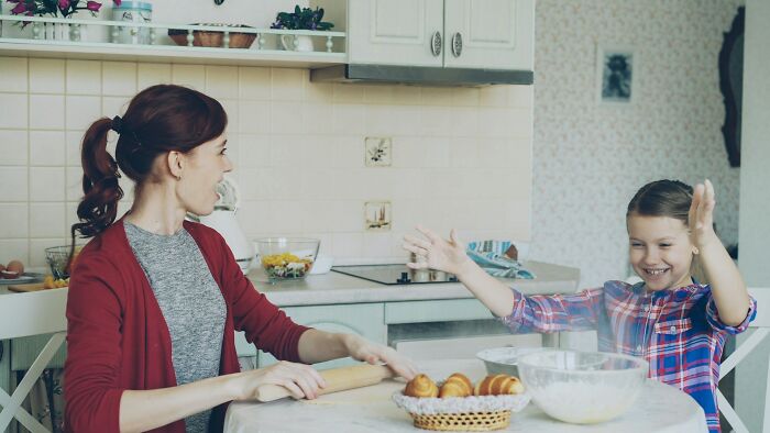 Mother and daughter enjoying baking together in kitchen, illustrating how random life decisions can lead to joyful moments.