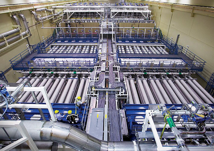 Large industrial scientific equipment with researchers in safety gear exploring big unproven scientific theories in a lab setting