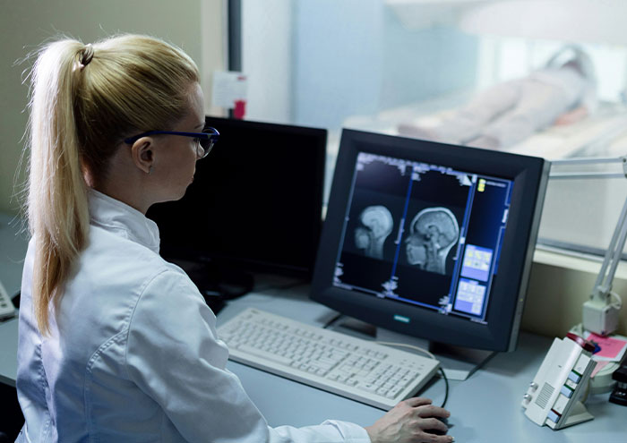 Scientist analyzing brain scans on computer in a lab exploring biggest theories not yet proven in science.