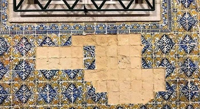 Missing azulejo tiles on a building facade, a common issue with tourists doing annoying things abroad and locals can't stand.