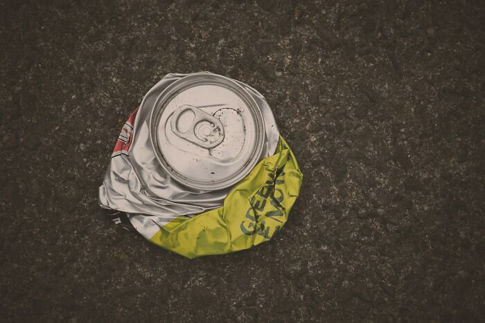 Crushed soda can on rough asphalt surface symbolizing careless moments related to kids with no survival instincts.