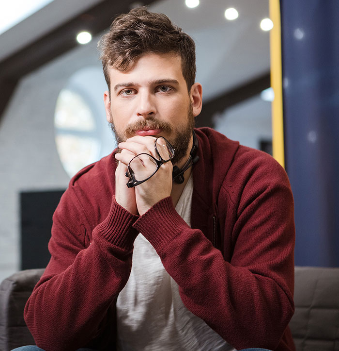 A man with a beard and glasses, looking thoughtfully at the camera, exemplifying when boyfriends and husbands were being mean.