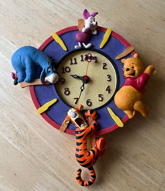 Winnie the Pooh clock with Pooh, Piglet, Eeyore, and Tigger figures. Features characters from stories.