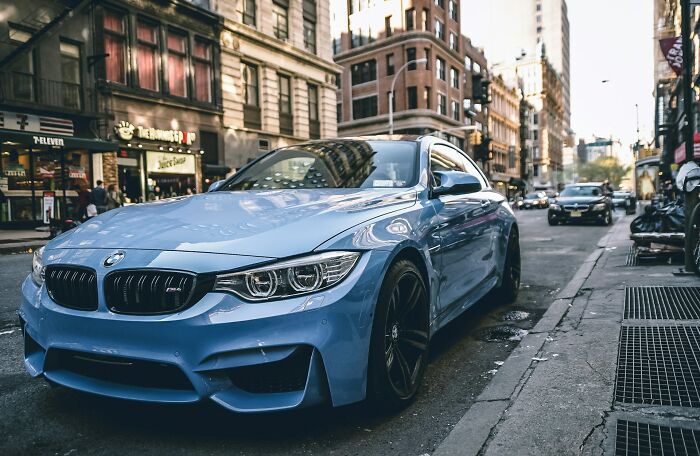 Blue BMW parked on a city street representing karma moments that come in all forms but are always satisfying in urban life.