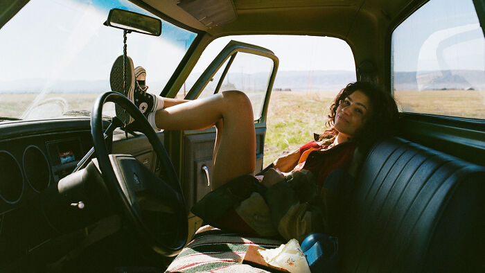 Mulher relaxando dentro de um carro estacionado com a porta aberta, evocando temas das críticas da estreia da 3ª temporada de Euphoria. Mulher relaxando dentro de um carro estacionado com a porta aberta, evocando temas das críticas da estreia da 3ª temporada de Euphoria.