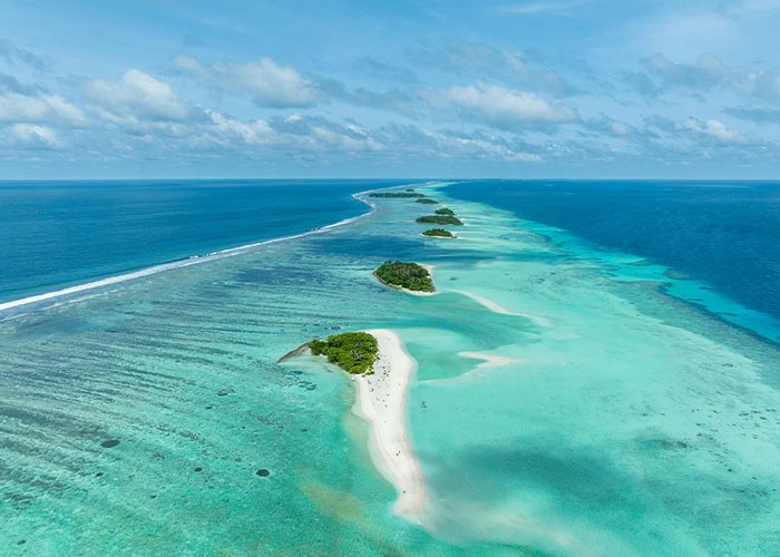 Aerial view of turquoise water and islands in Maldives diving location