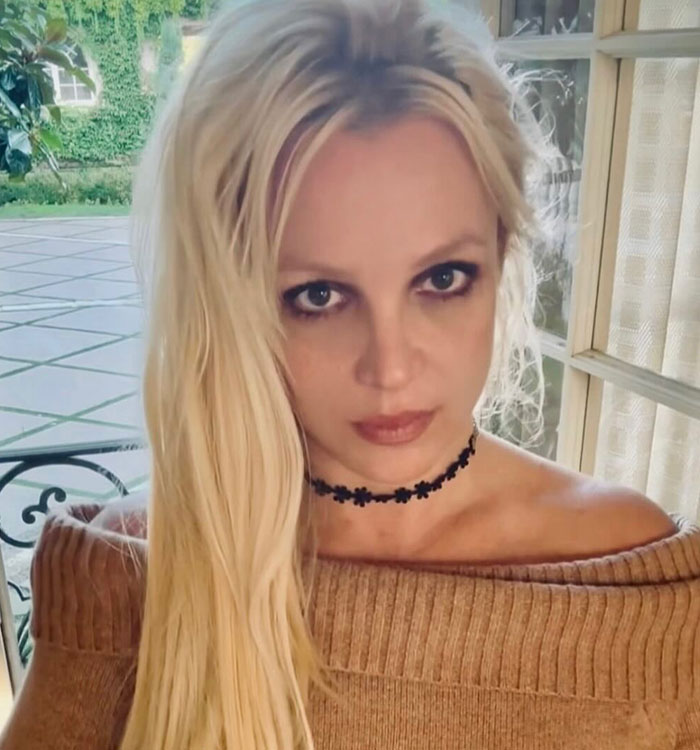 Close-up of Britney Spears with a serious expression wearing a choker