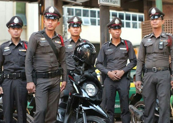 Group of Thai police officers standing with motorcycle at city street Group of Thai police officers standing with motorcycle at city street