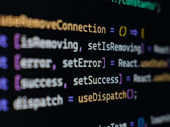 Close-up of developer code on a screen, with colorful text. Highlights how a system broke without a budget burden developer.