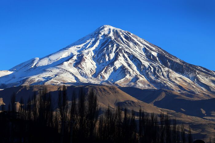 Snow-covered peak under blue sky with stunning mountain views