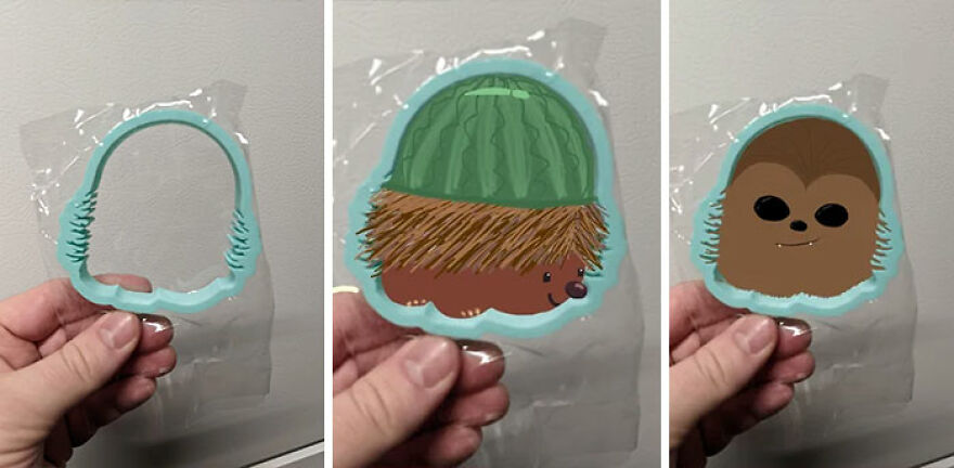 A hand holds a cookie cutter and two decorated cookie shapes; one is a hedgehog with a watermelon hat, the other is Chewbacca.