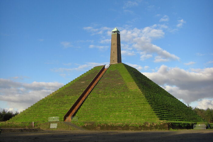 Green pyramidal monument with stairway under blue sky stunning views