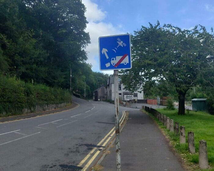 British street sign showing tow truck monitored by satellite