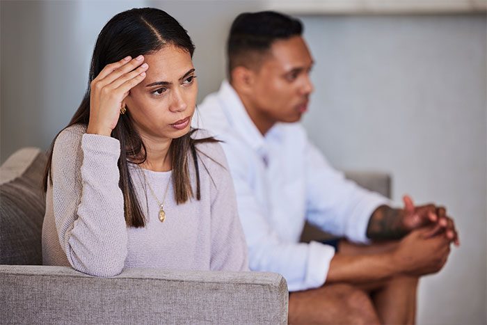 Unhappy married couple sitting apart showing strain in their marriage