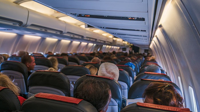 Spirit Airlines passengers in a full airplane cabin, heads of diverse people visible, highlighting the travel experience.