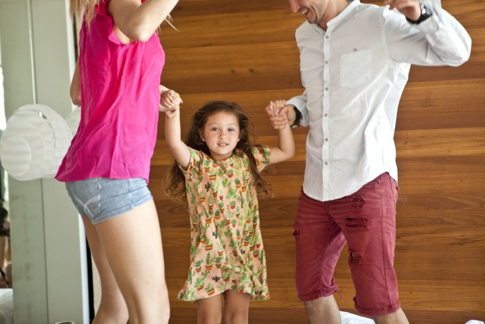 Parents joyfully playing with adopted daughter at home Parents joyfully playing with adopted daughter at home