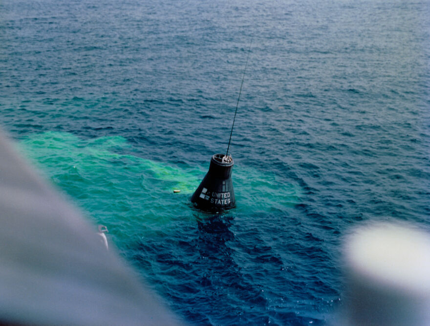 A United States space capsule floats in the ocean, a symbol of isolated places and leaving civilization behind.