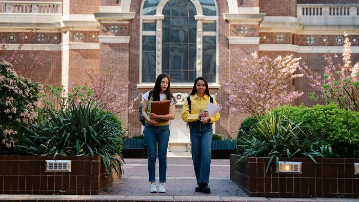 University students talking and walking in front of a college, relating to tell the truth or lie poll