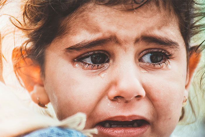 Close-up of crying child representing emotional impact in cult family