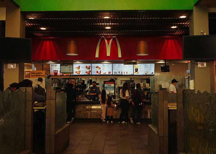 McDonalds counter with customers, challenging stereotypes about the US. People ordering food.