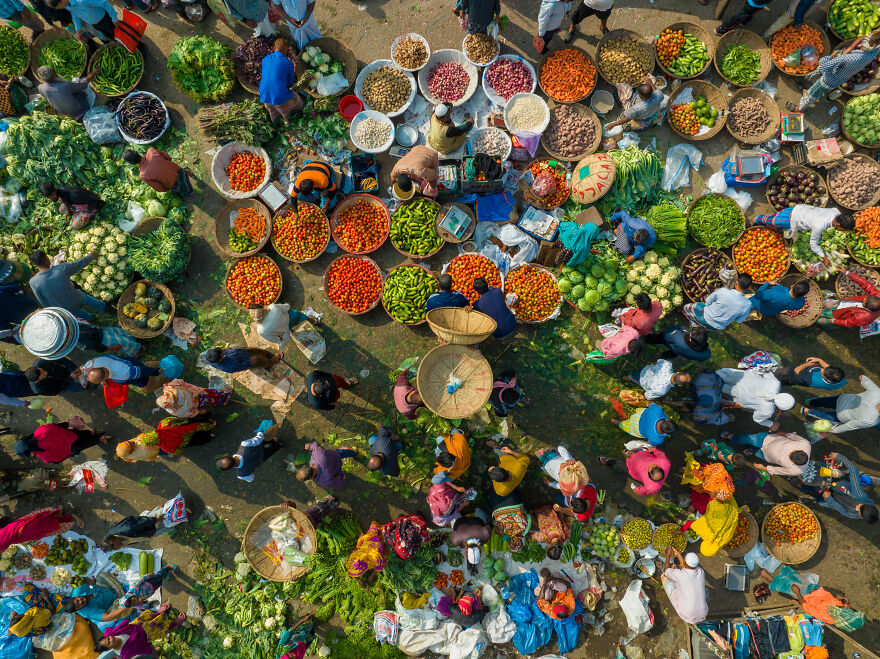 An aerial view of a bustling outdoor market with vendors and customers, showcasing a wide variety of fresh produce. This relates to countries with the worst diets.