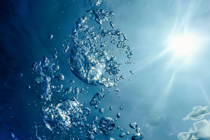Bright sunlight shining through water with countless bubbles, depicting stories that will stay with you after crossing to the other side.