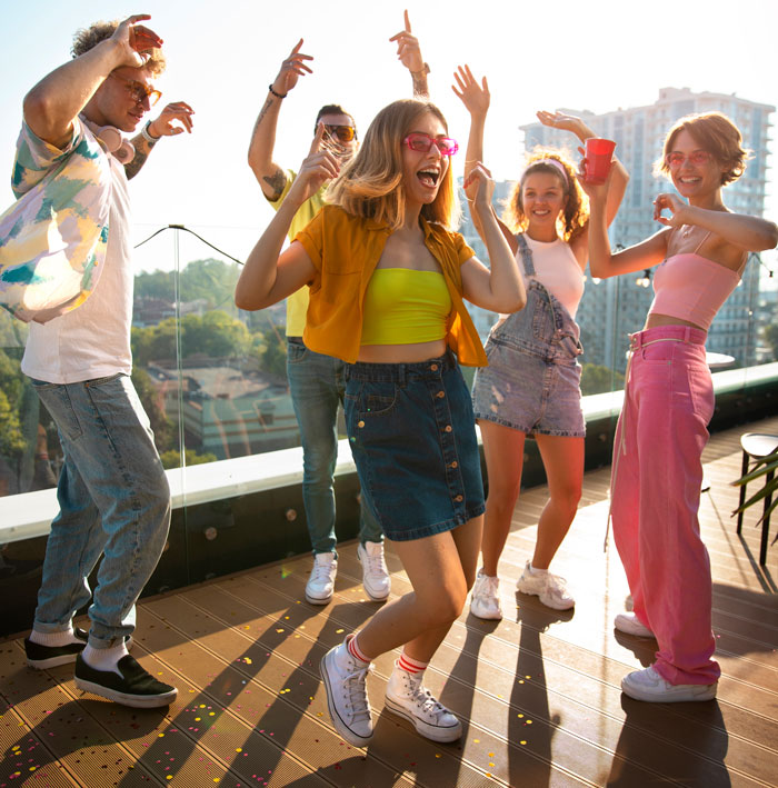 Friends dancing on a rooftop, laughing and having fun. They are celebrating, enjoying the moment. Wrong facts are not present here.