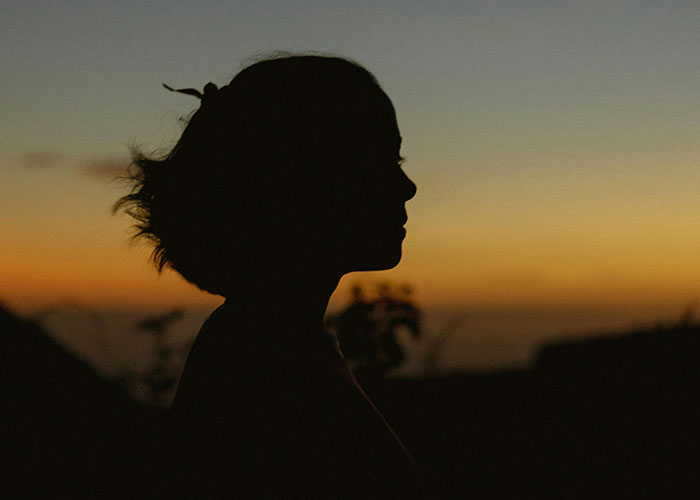 Silhouette of woman in profile at sunset outdoors