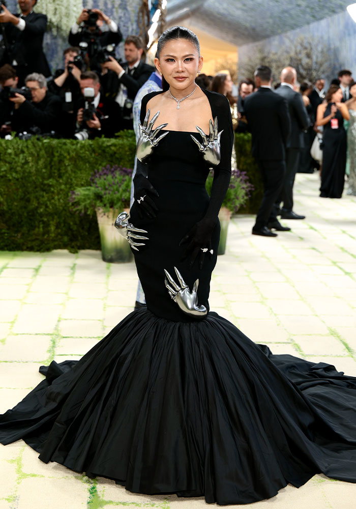 An Asian woman in a black gown with silver hand details, among the worst dressed stars at Met Gala 2026.