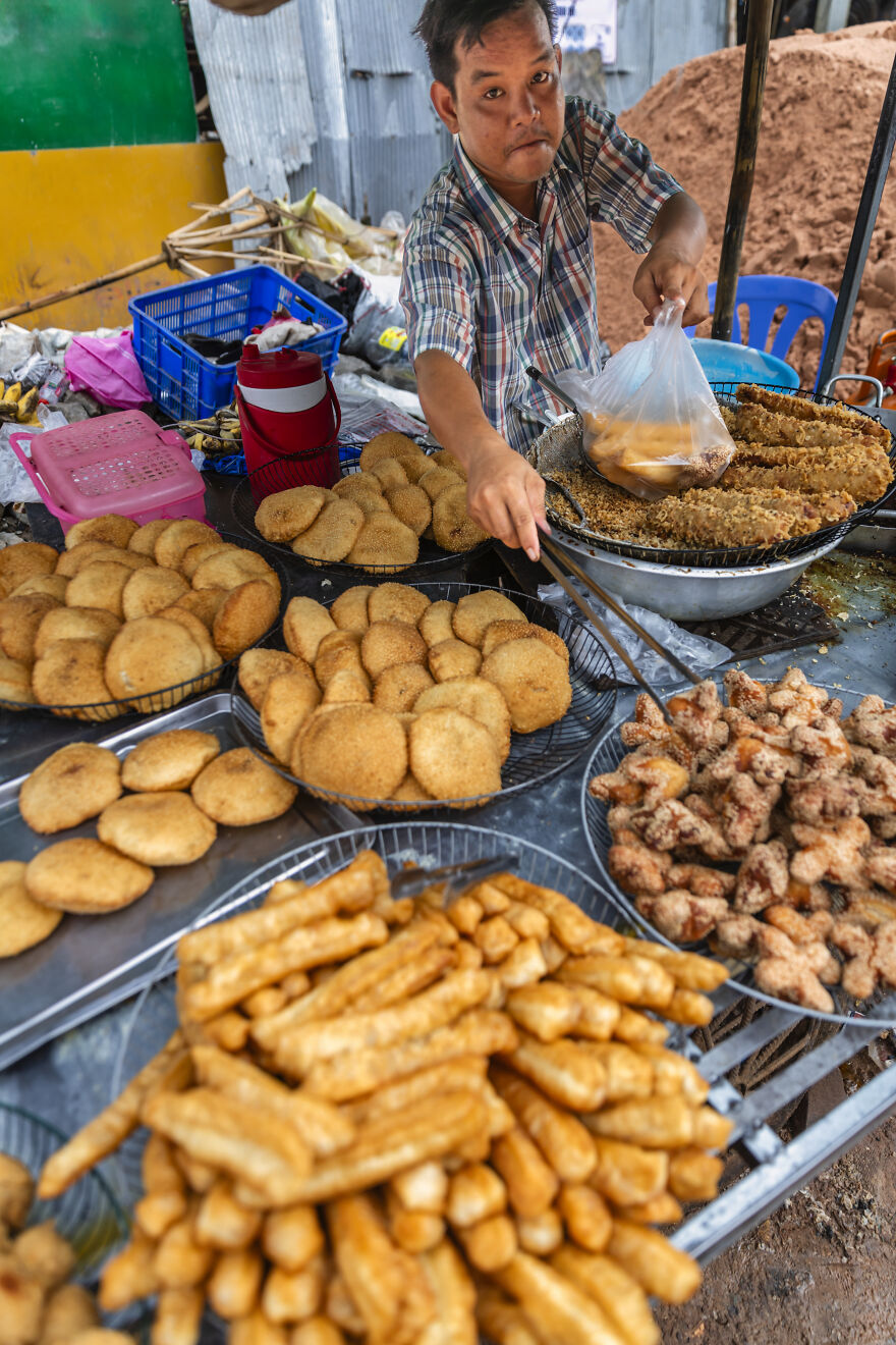 A street vendor serving various fried foods like pastries and fritters, reflecting potential worst diets.