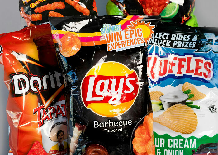 Assorted bags of snack chips like Lay's, Doritos, and Ruffles, suggesting consumer spending and concerns about their wallets.