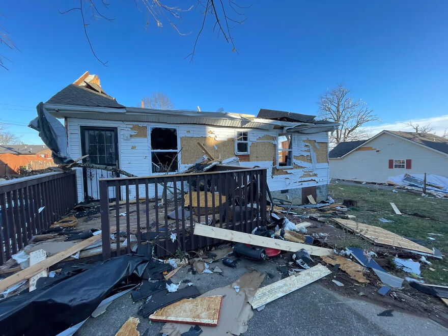 A severely damaged house, roof torn off, debris scattered. Illustrates the stressful jobs related to disaster recovery.