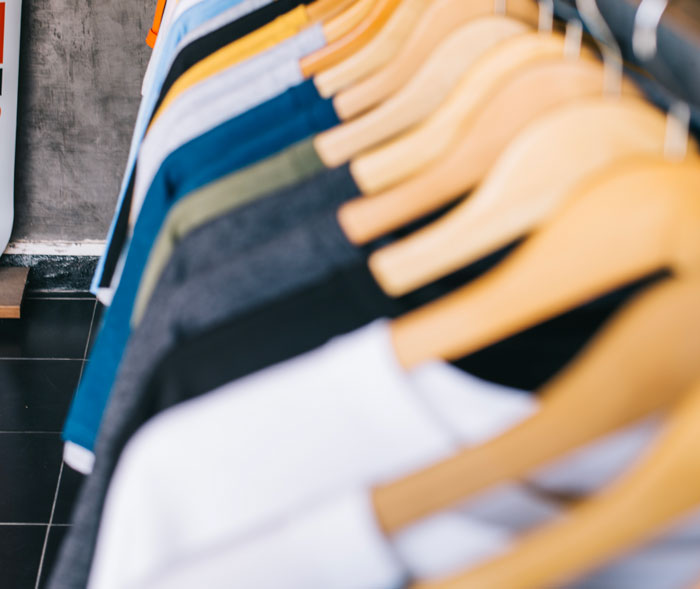Row of colorful t-shirts on hangers in store reflecting glitch in the matrix fashion