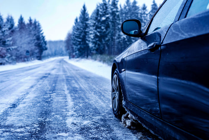 Car parked on icy road in snowy environment